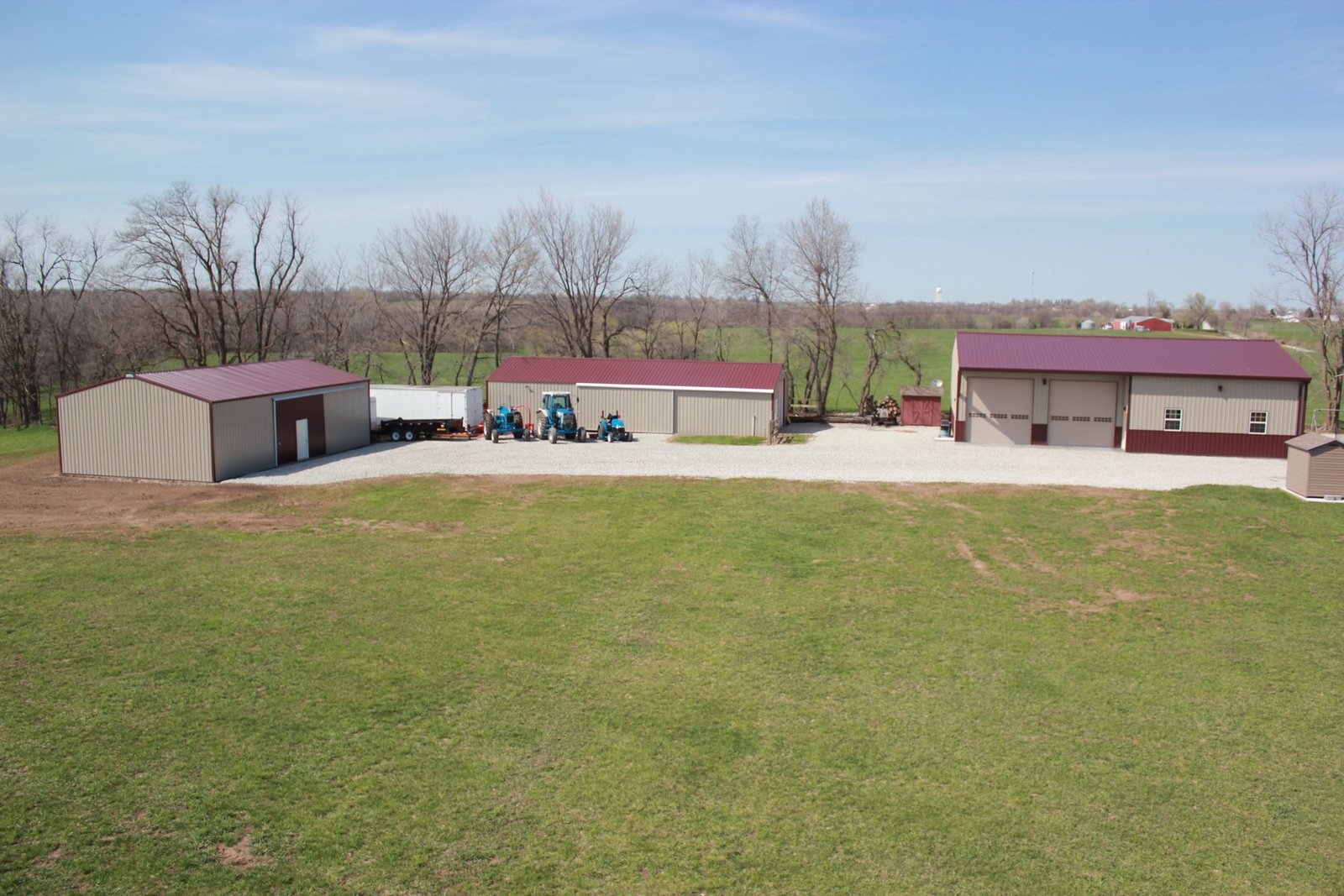Finished Veritas Built campus of matching tan-and-maroon metal buildings on a rural property
